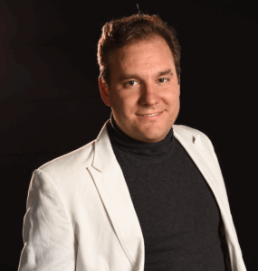 Offizielles Portrait des Drehbuchautors Elias Sasek in casual Business Look vro schwarzem Studiohintergrund